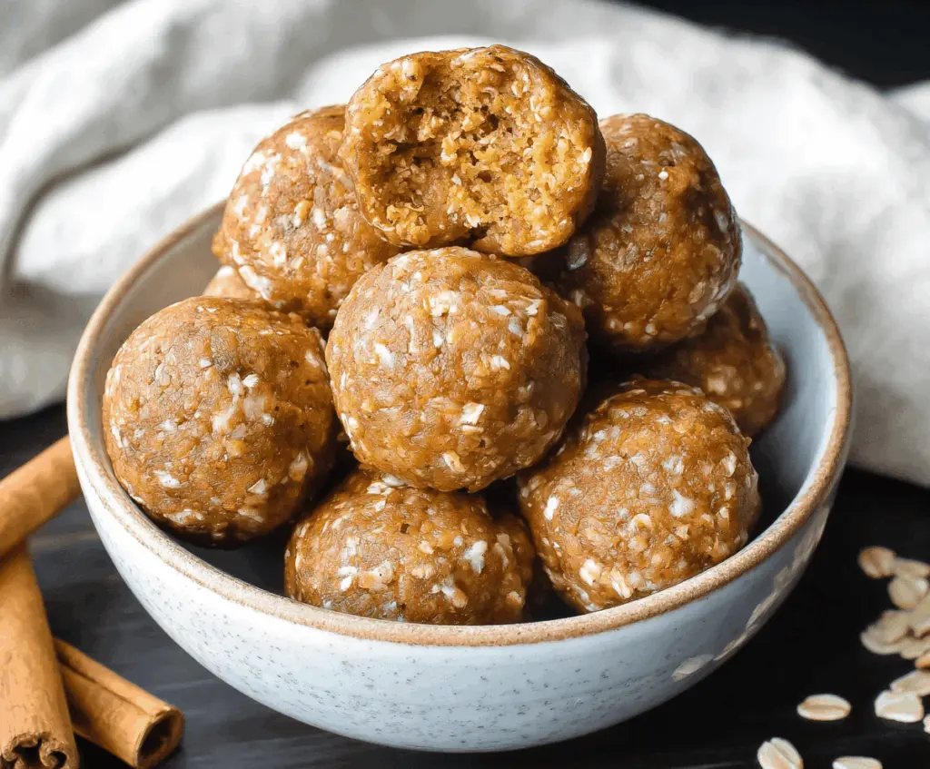 Healthy pumpkin spice protein balls on a white plate, featuring fall spices and seeds, perfect for a nutritious snack