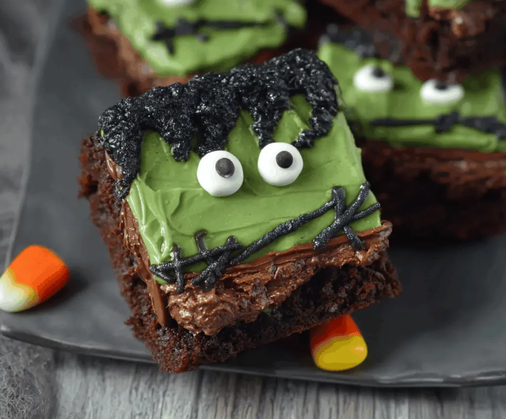 Decorative Frankenstein Brownies with green frosting, googly eyes, and spooky themed toppings for a fun Halloween treat