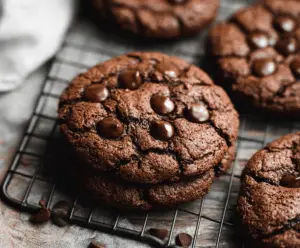 Delicious double chocolate chip cookies with melted chocolate chips on a baking tray.