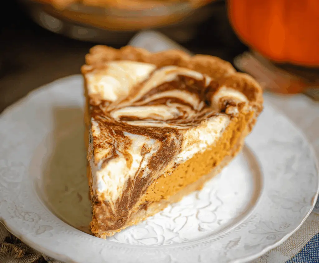 Delicious pumpkin cheesecake swirl pie with a creamy topping and a golden crust.