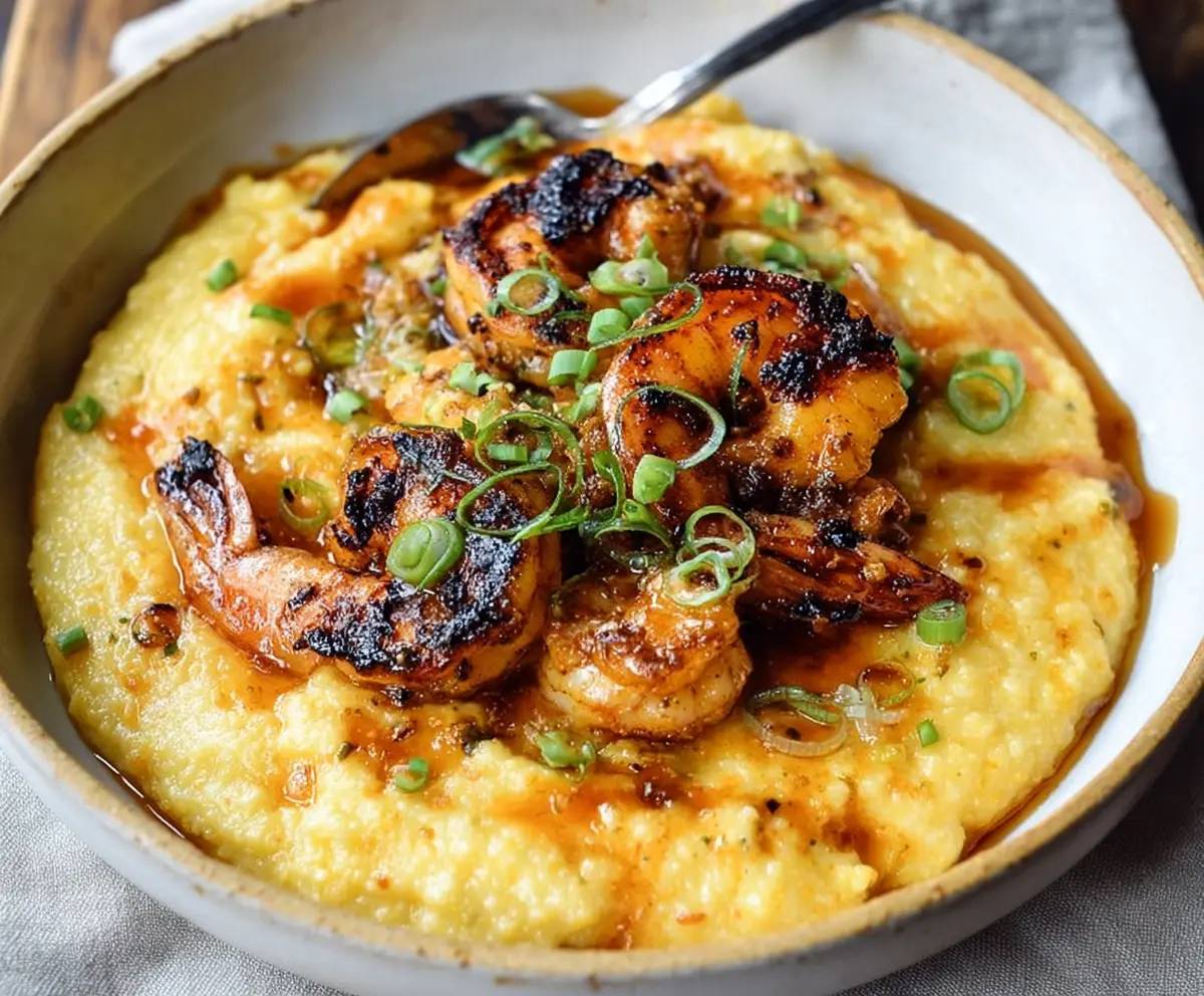 Delicious blackened shrimp served over creamy cheesy grits, perfect for a flavorful seafood meal.