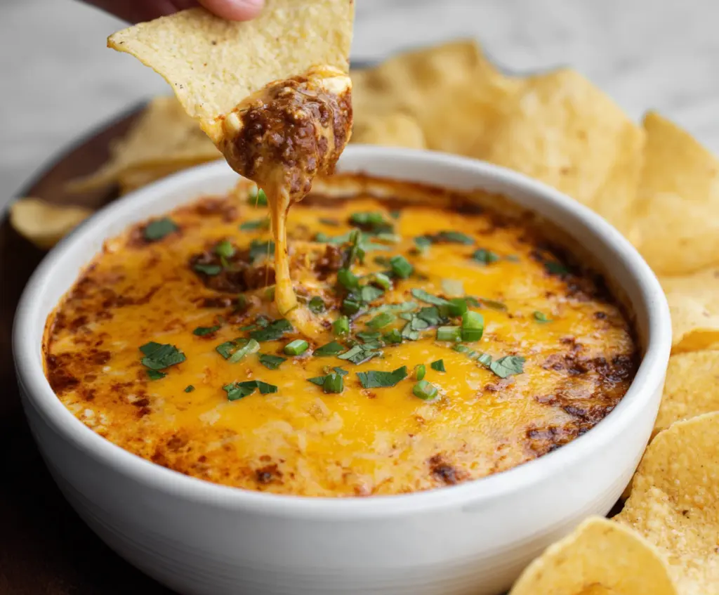 Creamy chili cheese dip served with tortilla chips, perfect for parties and snack time.