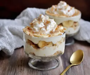 Delicious cottage cheese banana pudding served in a glass bowl, topped with fresh banana slices.
