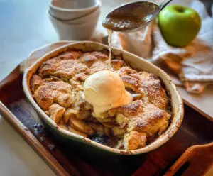 Delicious sourdough discard apple cobbler topped with golden crust and fresh apple slices.