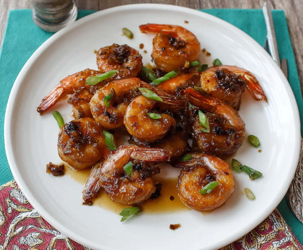 Delicious bourbon glazed shrimp with a shiny caramelized coating, served on a white plate.