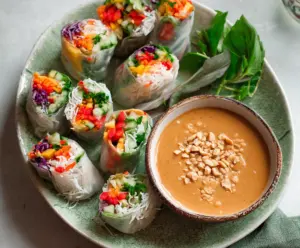 Delicious fresh spring rolls filled with vegetables and herbs, served with creamy peanut sauce.