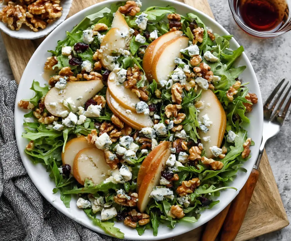 Fresh arugula salad with sliced pears, crumbled blue cheese, and walnuts, healthy and delicious.